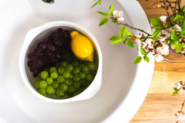 Fruits, lavage des baies, désinfection dans l'évier blanc. Cuisine vue du dessus intérieur — Photo