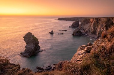 Bedruthan Basamakları 'nda gün batımı. Carnewas ve Bedruthan Steps, İngiltere 'nin Cornwall kentinde Padstow ve Newquay arasında yer alan bir kıyı şerididir.