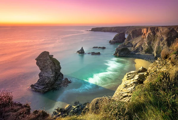 Bedruthan Basamakları 'nda gün batımı. Carnewas ve Bedruthan Steps, İngiltere 'nin Cornwall kentinde Padstow ve Newquay arasında yer alan bir kıyı şerididir.