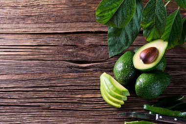 Avokado, metniniz için boş alan ile eski ahşap masa üzerinde ikiye bölün. Üstten Görünüm.