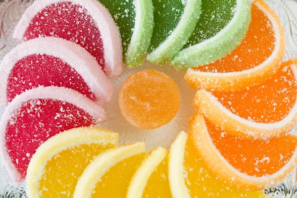 Coloridos caramelos de jalea de frutas dispuestos en círculo sobre una mesa de madera . —  Fotos de Stock