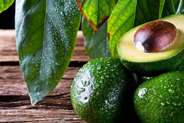 Eski ahşap masa üzerinde taze organik avokado. Yakın çekim fotoğraf kompozisyonu.