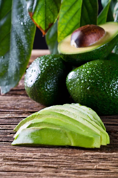 Eski ahşap masa üzerinde taze organik avokado. Yakın çekim fotoğraf kompozisyonu.