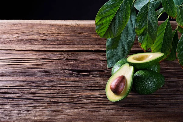 Avokado, metniniz için boş alan ile eski ahşap masa üzerinde ikiye bölün. Üstten Görünüm.