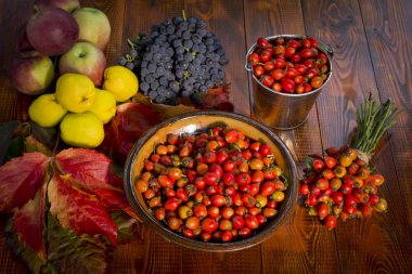 Kil kase rose hips ahşap arka plan üzerinde dolu. Sonbahar meyve içinde belgili tanımlık geçmiş.