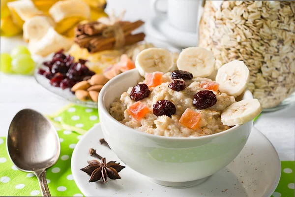  Yulaf lapası Kuruyemiş, kızılcık, muz ve baharatlar ile. Yulaf ezmesi zemin üzerine kavanoz. Beyaz arka plan üzerinde düzenlenmiş.