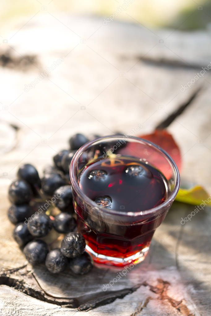 A glass of tincture of chokeberry.