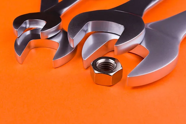 Turuncu arka plan üzerinde irili ufaklı somun anahtarları