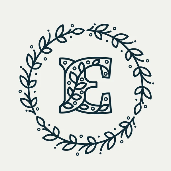 Logotipo de la letra E que consiste en un patrón floral en una corona de laurel círculo . — Vector de stock