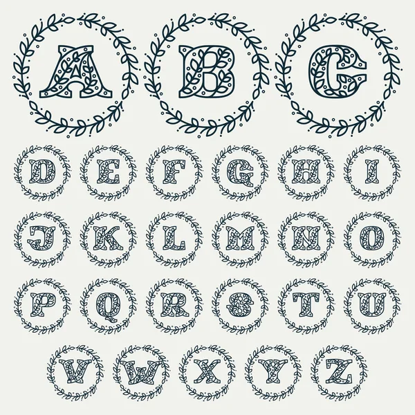 Alfabeto composto por letras padrão florais em uma coroa de louro círculo . —  Vetores de Stock