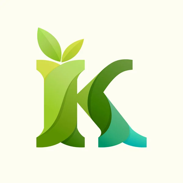 Wirująca litera K logo z zielonymi liśćmi. — Wektor stockowy