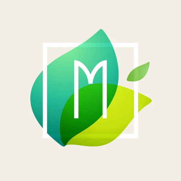 M letter logo in square frame at green leaves watercolor backgro — Stock Vector