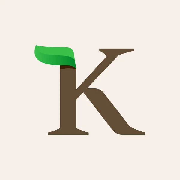 Ökologie k serifenbuchstabe logo mit grünem blatt. — Stockvektor