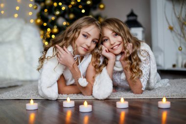 Kızlar İkizler önünde mumlar ile köknar ağacı. 