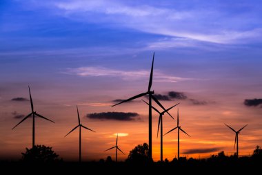 Gün batımında rüzgar türbinleri silueti