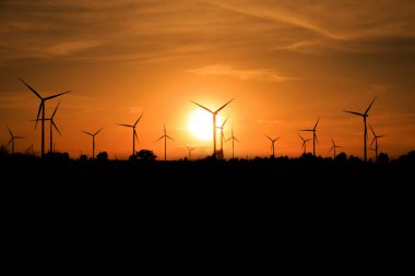 Gün batımında rüzgar türbinleri silueti