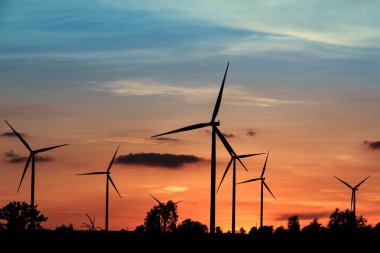 Gün batımında rüzgar türbinleri silueti