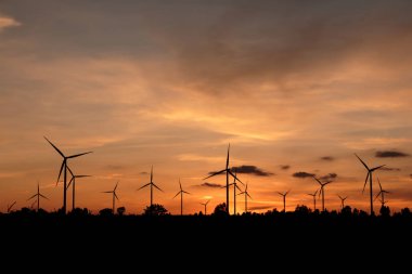 Gün batımında rüzgar türbinleri silueti