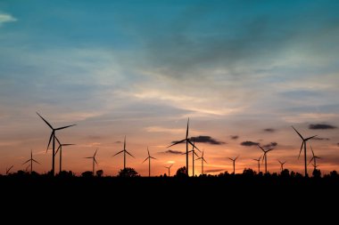 Gün batımında rüzgar türbinleri silueti