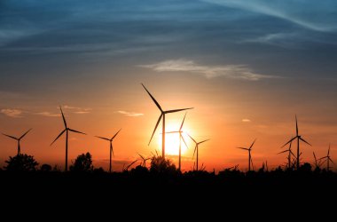 Gün batımında rüzgar türbinleri silueti