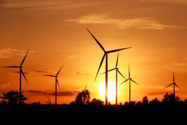 Gün batımında rüzgar türbinleri silueti