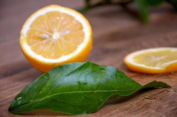    Limon yaprakları ile dilimlenmiş. Ahşap arka plan üzerinde. Üstten Görünüm