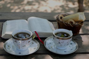 ahşap masa açık kitap, birkaç bardak kahve