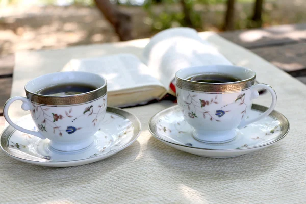 ahşap masa açık kitap, birkaç bardak kahve
