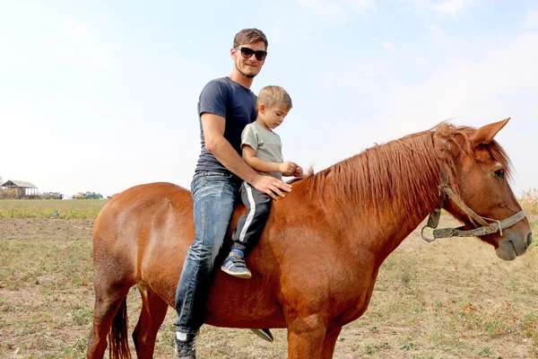Baba ve oğul alanındaki kırmızı ata binme