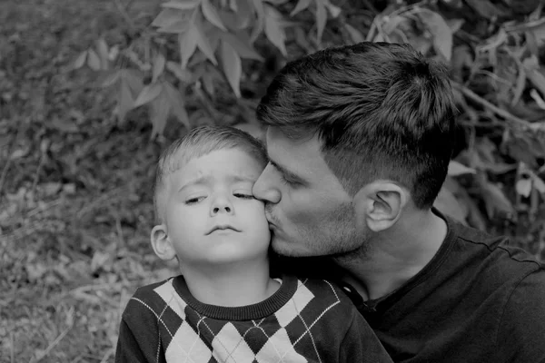 Father holds his son in his arms, kiss on the cheek — Stock Photo, Image