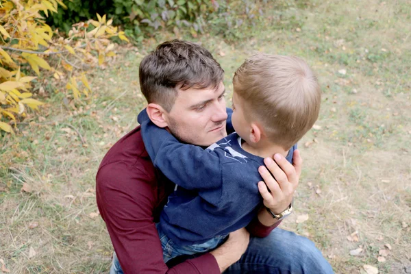 Father is looking at his small handsome cute son in his arms, — Stock Photo, Image