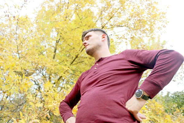 husband outdoors in autumn, arms akimbo