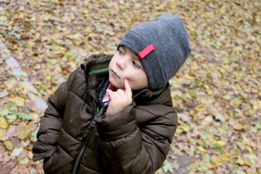 Küçük yakışıklı ciddi yakışıklı bir kap içinde arka plan ve ciddi ciddi düşünüyorum görünüyor