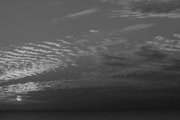 Magisch zwart-wit stappen in de hemel, de ongebruikelijke prachtige zonsondergang in de winter, bewolkte hemel, straal van de zon in de zee van wolken — Stockfoto