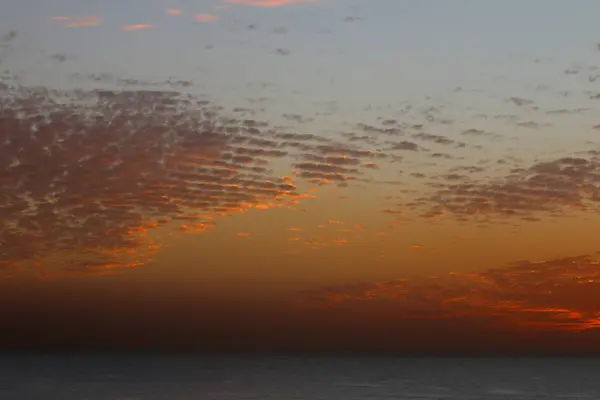 Velmi krásný červený západ slunce v zimě, zamračená obloha, sun ray v oblačném moři — Stock fotografie