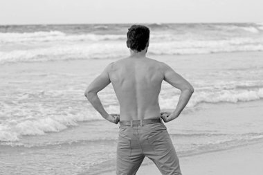 Sahilde bir adamın gövdesini gösteriyor.