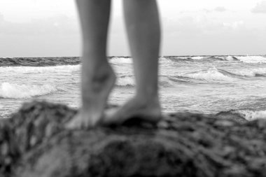 Denizdeki kayanın üstünde ayakçı kız. Stoit kızı büyük taşın üstünde