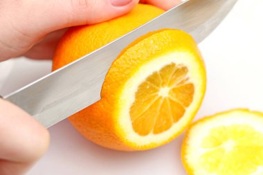 diğer el meyve mutfakta holding beyaz bir arka planda turuncu parçacıklar çelik bıçak için dilimlenmiş