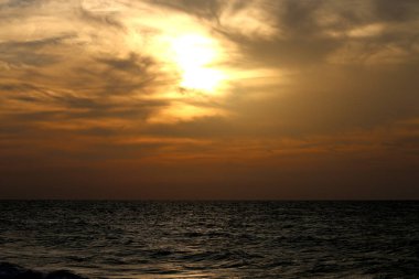 Denizde bulutlu gün batımı sessiz gece