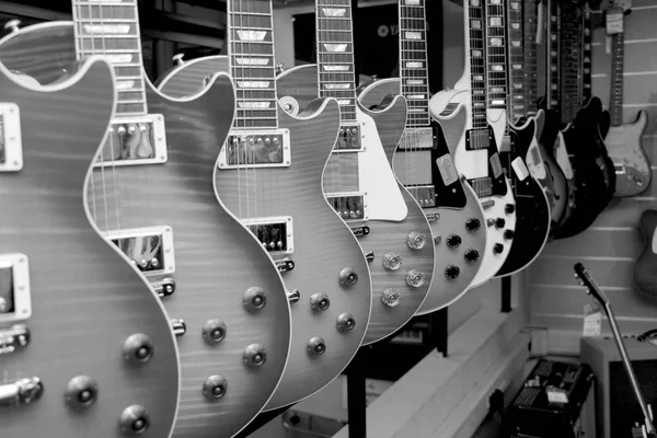 Un gran número de guitarras eléctricas en el mostrador en la tienda — Foto de Stock