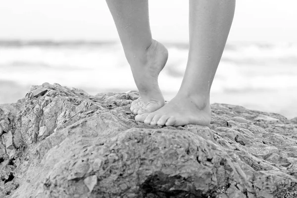 Босые ноги девушки на фоне моря на берегу — стоковое фото