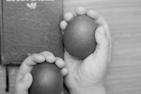 Ovos de Páscoa, juntamente com um livro sobre um fundo de madeira Biblileyu — Fotografia de Stock