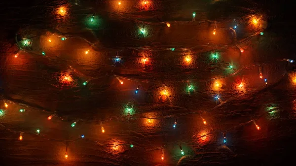 Colored Christmas garland on the background of the old wall. atmospheric light bulbs — Stock Photo, Image