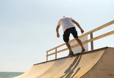 adam kaykaycı güneşli bir günde bir rampa üzerinde sürmek