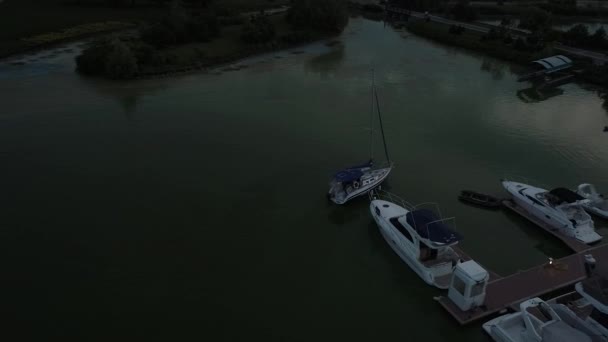 空中上のパノラマビュードローンのコッパーの空気は美しい川の上を飛んで空を飛ぶ パステルカラーの曇りの空と日没の柔らかい光 壮大な風景です 4K解像度ヨットボート係留 — ストック動画