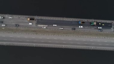 Arabalar nehrin üzerindeki iki köprüye binerler. Kamera aşağı doğru daha yüksek bir yüksekliğe yükselir ve döner. Hava panoramik üst görünümü uçan gökyüzü görüntüsü İHA ile çekim.
