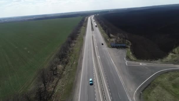 Vue aérienne de la voiture SUV croisée conduisant le long de la route de gravier vide à travers les prairies verdoyantes paysage par une matinée ensoleillée. Drone poursuit une voiture .