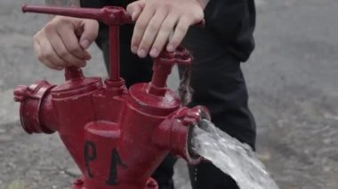 Fire hydrant ready to connect hose during fire fighting outdoors. Old red fire hydrant