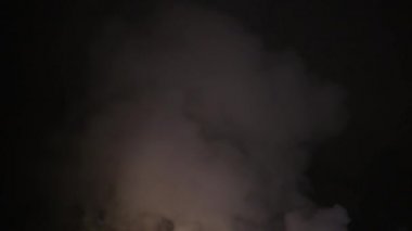 Şehir caddesinde yangın söndürücüyle yangını söndürmeye çalışan ama içerisi tamamen yanmış bir araba yangını.