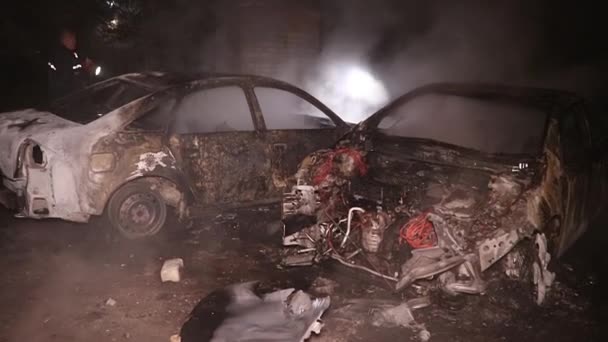 城市街道上的一名男子企图用灭火器扑灭一场大火 但被完全烧毁了的汽车失火 — 图库视频影像